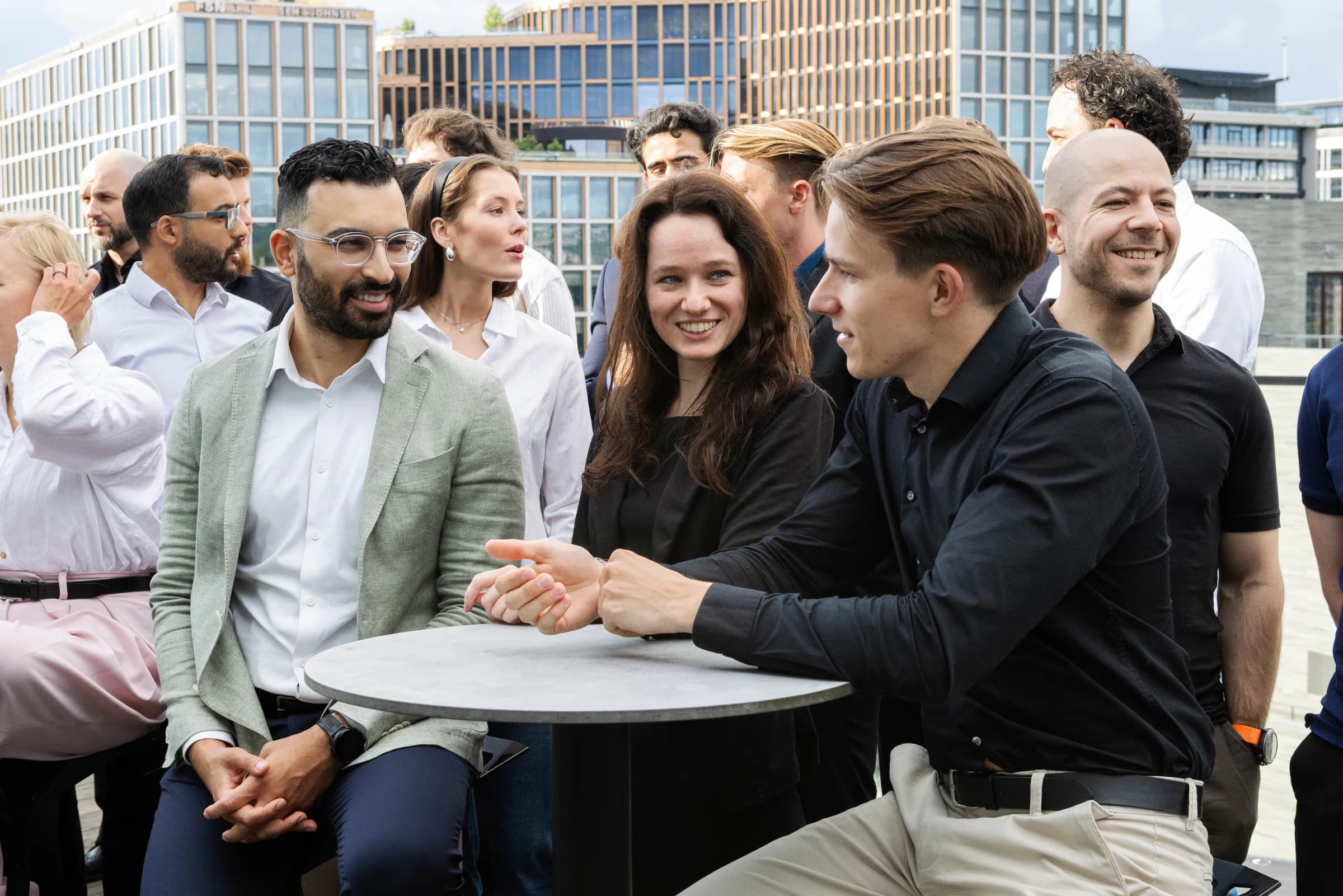 The Newcode team around a table on the office terrace